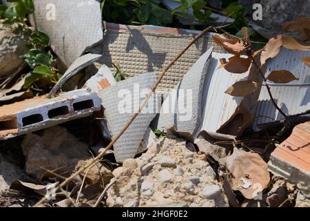 Les gravats de maçonnerie dans lesquels il y a des briques et des restes de plaques d'amiante (ciment d'amiante) dans une zone rurale Banque D'Images