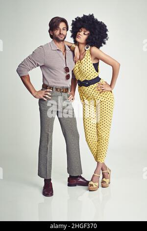 Couple rétro.Un jeune couple attrayant debout ensemble dans des vêtements rétro 70s. Banque D'Images