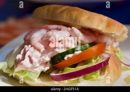 Sandwich déjeuner avec crevettes pelées, mayonnaise avec fruits de mer et tranches de légumes dans le pain. Banque D'Images