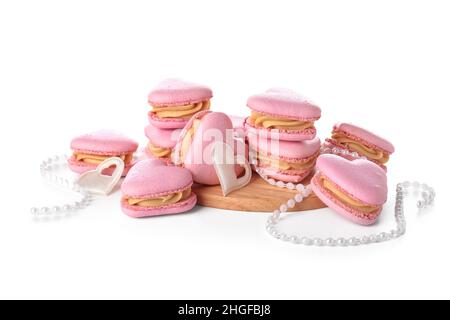 Macarons et perles en forme de cœur savoureux sur fond blanc Banque D'Images