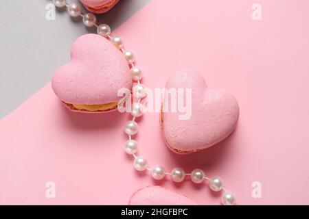 Macarons et perles en forme de cœur savoureux sur fond de couleur Banque D'Images