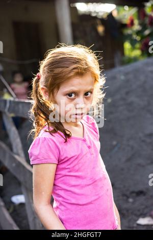 Une jeune fille nicaraguayenne aux cheveux rouges regarde avec appréhension la caméra dans le département rural de Jinotega, au Nicaragua. Banque D'Images