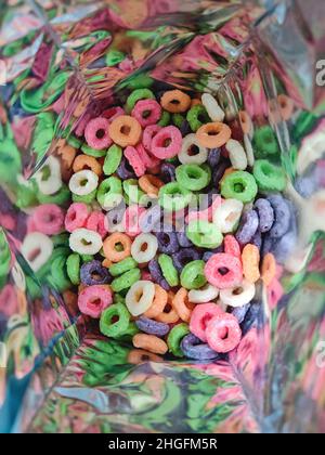 Anneaux de céréales aux fruits et au maïs sucrés colorés. Gros plan de ce petit déjeuner et en-cas savoureux et nourrissants. Banque D'Images