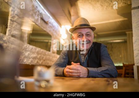 PRODUCTION - 14 janvier 2022, Hessen, Francfort-sur-le-main: Kostas (Konstantinos) Tsapakidis est assis à une table dans la soirée dans son restaurant grec appelé 'Taverna Omikron' dans le quartier de Bockenheim, qu'il court depuis environ 30 ans.(À dpa 'Taverna 'Omikron', Ice café 'Corona' - les noms des entreprises et la pandémie') photo: Frank Rumpenhorst/dpa/Frank Rumpenhorst/dpa Banque D'Images