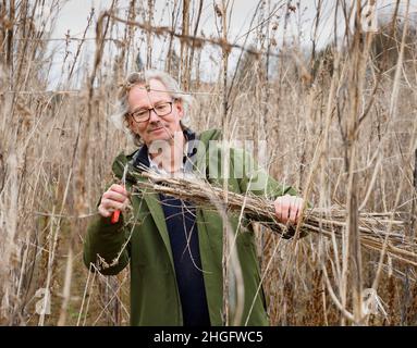 18 janvier 2022, Brandenburg, Wittstock/Dosse/OT Zempow: L'agriculteur Wilhelm Schäkel coupe le chanvre commercial dans un champ au Bio Ranch et lie les plantes dans un paquet.Le chanvre est particulièrement adapté au matériau d'isolation.Schäkel est l'un des 15 agriculteurs du district d'Ostprignitz-Ruppin de Brandebourg et de l'État voisin de Mecklembourg-Poméranie occidentale qui sont légalement impliqués dans la culture du chanvre commercial.(À dpa 'domaine d'activité intéressant pour les agriculteurs: Culture du chanvre commercial') photo: Soeren Stache/dpa-Zentralbild/dpa Banque D'Images