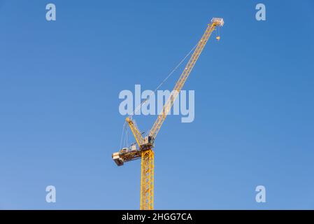 Grande grue de construction jaune contre ciel bleu clair Banque D'Images