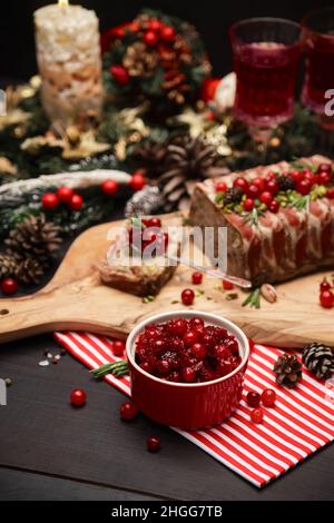 Sauce aux canneberges avec terrine française traditionnelle sur fond de bois sombre et décorations de Noël Banque D'Images