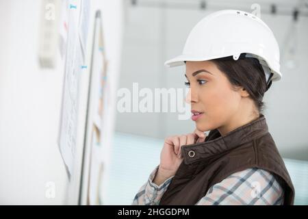 belle femme d'architecte portant un casque avec un visage réfléchi Banque D'Images