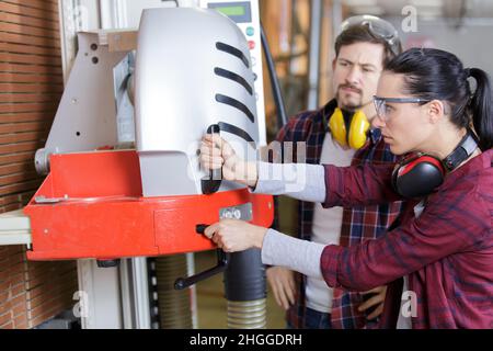 menuisier enseignant à l'apprenti comment couper le bois Banque D'Images