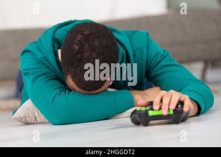 triste homme avec manette de jeu dans les mains jouant au jeu vidéo Banque D'Images
