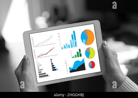Concept d'analyse graphique présenté sur une tablette tenue par une femme Banque D'Images