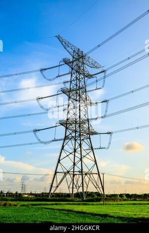 Tour de puissance haute tension paysage industriel au lever du soleil, lignes de transmission de puissance urbaine. Banque D'Images