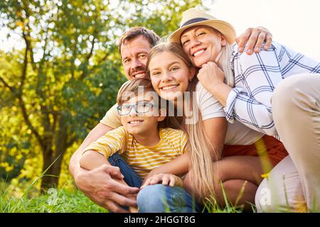 Famille heureuse avec deux enfants comme petite famille harmonieuse dans la nature dans le parc Banque D'Images