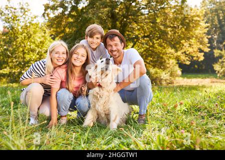 Famille heureuse avec deux enfants et chien de retriever en été dans la nature Banque D'Images