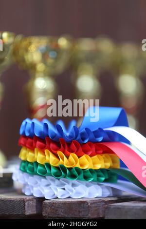 Groupe de trophées et insignes de sport équestre rosettes à l'événement équestre dans la rangée.Pile de trophées de sport et de badges rosettes pour les gagnants du spectacle Banque D'Images