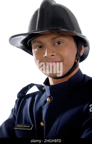 Inde - 26 décembre 2009 - un studio de mannequin masculin a tiré un jeune caucasien indien et un pompier fort en uniforme portant un casque sur fond blanc de la tête. Banque D'Images