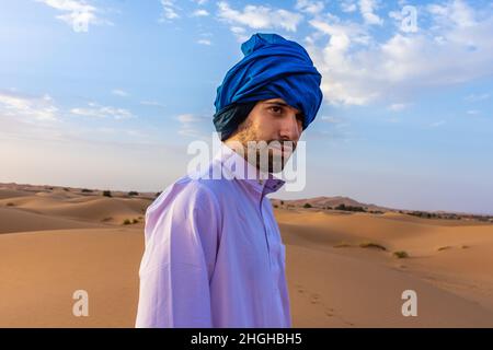 Jeune arabe portant des vêtements berbères traditionnels dans le désert du Sahara de Merzouga, au Maroc Banque D'Images