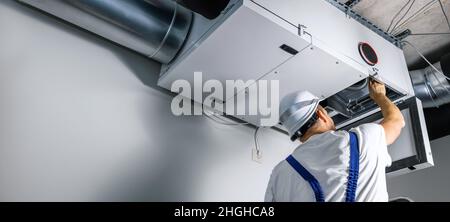 un ingénieur hvac installe un système de ventilation de récupération de chaleur pour la nouvelle maison. copier l'espace Banque D'Images