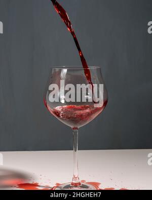 Vin rouge versé dans un grand verre en Toscane avec un fond neutre. Banque D'Images