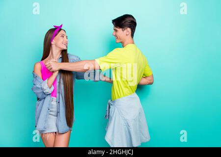 Profil photo de cute brunette millénaire couple danse porter t-shirts roses coiffeur jeans chemise isolée sur fond turquoise couleur Banque D'Images