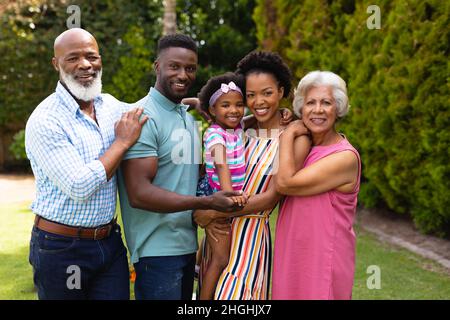 Portrait d'une famille afro-américaine souriante de trois générations debout dans un jardin Banque D'Images