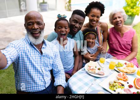 Portrait d'une famille afro-américaine joyeuse de trois générations prenant le selfie au brunch Banque D'Images
