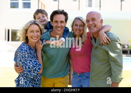 Portrait d'une famille de trois générations de caucasiens souriant tout en se tenant ensemble dans le jardin Banque D'Images