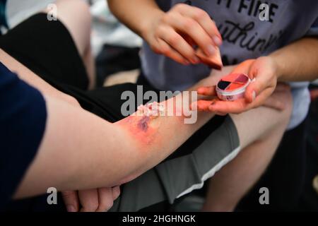 Un Airman applique une simulation de maquillage de plaie au bras d’un autre Airman pendant l’exercice Ready Eagle le 6 août 2021, à la base aérienne de Beale, en Californie. Des blessures simulées ont été appliquées à plusieurs aviateurs qui ont été victimes d'une explosion de victimes de masse, permettant aux médecins du 9e Groupe médical de s'entraîner sur les procédures d'intervention. Banque D'Images