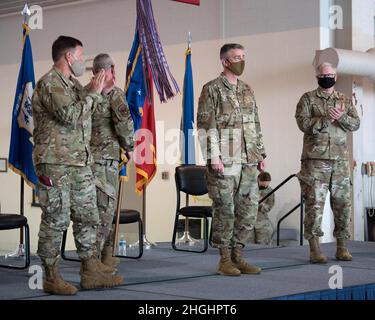 Bang. Le général Jeffrey Wilkinson (à gauche), adjoint de l’adjudant-général de l’Air du Kentucky, et le colonel David Mounkes (à droite), commandant sortant de la 123e Escadre de transport aérien de la Garde nationale de l’Air du Kentucky, applaudissent le colonel Bruce Bancroft, Qui a officiellement pris le commandement de l'aile lors d'une cérémonie à la base de la Garde nationale aérienne du Kentucky à Louisville, Ky., le 7 août 2021. Mounkes, qui était commandant d'escadre depuis 2016, a été nommé directeur de la politique des opérations, plans et programmes aériens au quartier général des Forces interarmées—Kentucky. Banque D'Images