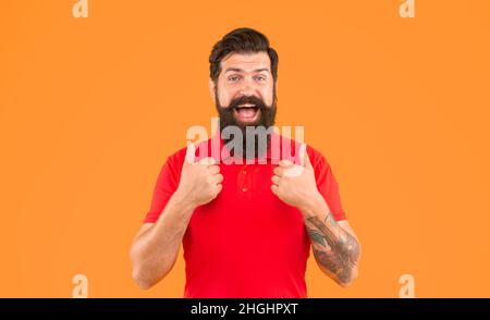 joyeux gars avec la barbe et la coiffure montrant le pouce vers le haut sur fond jaune, soin de peau Banque D'Images