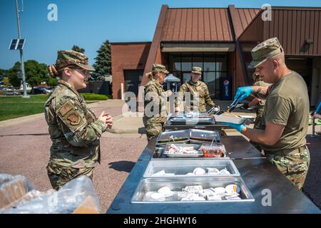 Les aviateurs du 114e Escadron de soutien de la Force servent le déjeuner de la remorque de cuisine mobile de secours en cas de catastrophe, ou DRMKT, lors de l'exercice de préparation de 2021 à Joe Foss Field, Dakota du Sud, le 5 août 2021. Le 114e Escadron de soutien de la Force a utilisé le DRMKT dans le cadre de son entraînement multicellulaire Airman au cours de l'exercice de préparation de 2021. Banque D'Images