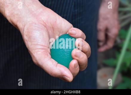 Asie du Sud-est, vieux chinois saisissant main exercice élastique boule. Banque D'Images