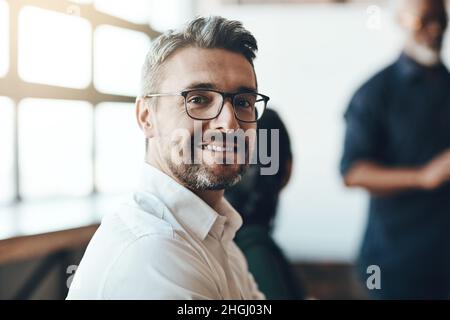 Je fixe toujours de nouveaux objectifs.Portrait court d'un homme d'affaires assis dans la salle de réunion lors d'une présentation. Banque D'Images