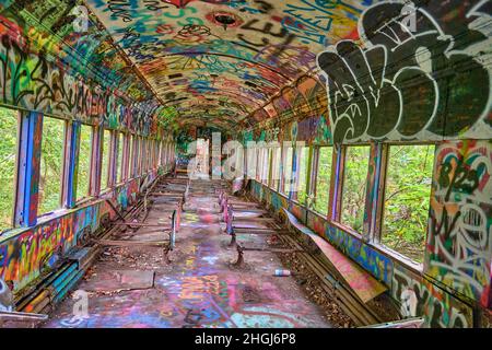 Intérieur d'un wagon abandonné avec graffiti aux couleurs vives sur le chemin de halage du canal du fleuve Delaware à Lambertville NJ USA près de New Hope PA. Banque D'Images