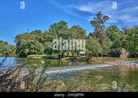 Neshaminy Creek, dans le parc national de Tyler, dans le comté de Bucks, Pennsylvanie, États-Unis.Avec de petites cascades et des canoës hauts en couleur.Un beau ciel bleu. Banque D'Images