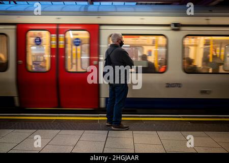 Londres, Royaume-Uni.21 janvier 2021.Un homme attend un tube à Baker Street.Le gouvernement britannique a récemment annoncé l'assouplissement des restrictions mises en place pour lutter contre la variante d'Omicron, comme le port obligatoire de masques dans les transports publics et dans les magasins, les conseils pour travailler à domicile et les certificats de vaccination.Cependant, le maire de Londres a déclaré que les revêtements de visage seront toujours une condition de transport sur les réseaux de transport pour Londres (TFL).Credit: Stephen Chung / Alamy Live News Banque D'Images