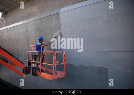 210818-N-KY668-1036 PONCE, Porto Rico - (août 18, 2021) – Mineman 2e classe John Cox affecté au navire de combat littoral Freedom-variant USS Billings (LCS 15) peint la coque du navire, le 18 août 2021. Billings est déployé dans la zone d’opérations de la 4e flotte des États-Unis pour appuyer la mission de la Force opérationnelle interagences conjointe Sud, qui comprend des missions de lutte contre le trafic illicite de drogues dans les Caraïbes et le Pacifique oriental. Banque D'Images