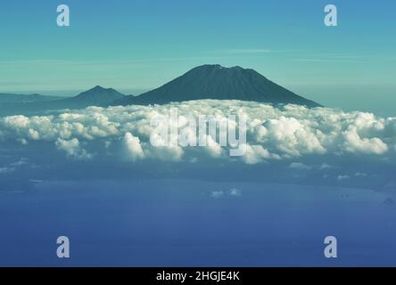 Vue aérienne du volcan du Mont Agung parmi les nuages et le littoral de Bali, Indonésie, Banque D'Images