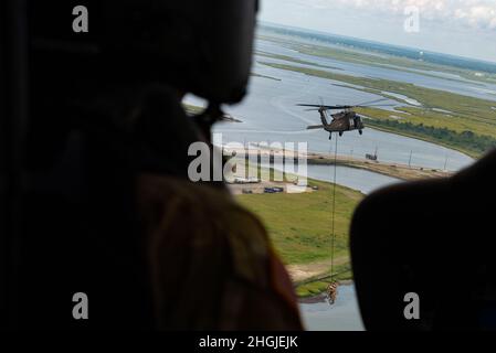 Les membres du 227e Escadron des opérations de soutien aérien de la 177e Escadre des chasseurs et une équipe d'hélicoptères UH-60 Black Hawk de la Garde nationale du New Jersey, du bataillon des hélicoptères d'assaut 1-150, effectuent une démonstration de l'insertion et de l'exfiltration de la patrouille spéciale (ESPIONS) et de l'infiltration et extraction rapides de corde (FRITES) le 18 août 2021, Au-dessus d'Atlantic City, N.J. La démonstration DE SPIES and FRIES a été l'un des nombreux actes réalisés au salon de l'air d'Atlantic City en 2021, « Un salut pour ceux qui servent ». Banque D'Images