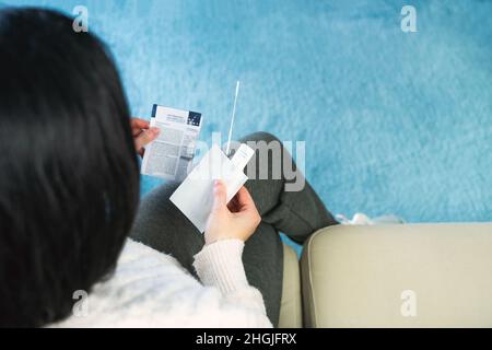 Femme assise lisant les instructions du test d'antigène pour le test Covid 19.Copier l'espace.Concept de coronavirus. Banque D'Images