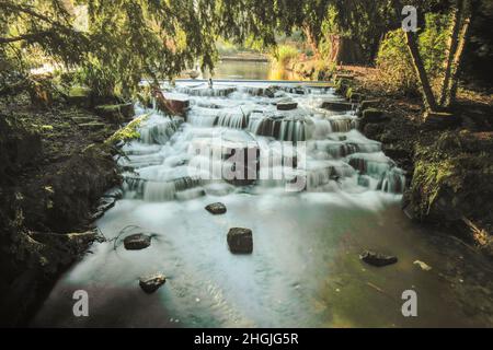 Paysage intime de la rivière Wandle eau tombant dans Grove Park (Sutton), Angleterre Banque D'Images