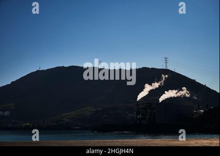 Deux cheminées émettant de la fumée blanche à l'aube sur la mer Banque D'Images