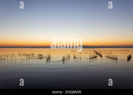 Coucher de soleil sur le lac d'Albufera à Valence avec les filets des pêcheurs en premier plan. Banque D'Images