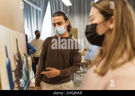 Jeunes étudiants portant un masque facial pendant la leçon à la faculté des arts université - apprentissage et concept de culture Banque D'Images