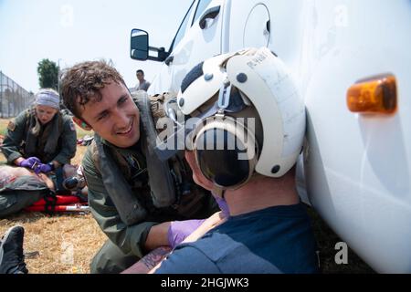 210824-N-EV253-1244 SAN DIEGO (AOÛT 24, 2021) Marine Aircrewman (hélicoptère) de 2e classe Joseph Furze, de Jersey Shore (New Jersey), et affecté aux « Chargers » de l’Escadron de combat de la mer (HSC) 14, rend l’aide médicale à une victime d’accident de voiture simulé lors d’une évaluation de recherche et sauvetage (SAR) terrestre le 24 août 2021. Au cours de la simulation, le HSC-14 a été évalué par le « Merlins » de l'Escadron de combat en mer (HSC) 3 Chef de l'équipe d'évaluation SAR du modèle de gestion des opérations navales (SARMM), responsable du commandant de la Force aérienne navale du Pacifique. En tant que SARMM désigné, HSC-3 s'en assure Banque D'Images