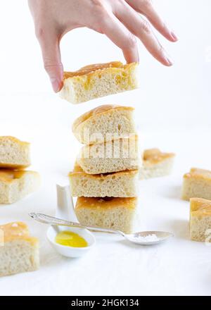 Pain italien focaccia coupé en tranches, une tranche tenue à la main Banque D'Images