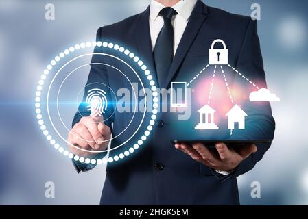 Homme en veste scannant son empreinte digitale pour accéder à sa technologie et la déverrouiller.Accès sécurisé et protection des empreintes digitales Banque D'Images