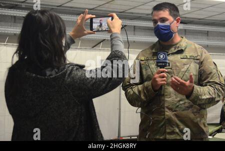 CPT. Alex Lovely, 16e officier de la brigade de soutien en charge de la zone de logement des évacués à la caserne de l'Ordnance du Rhin explique le logement, les soins et l'alimentation des voyageurs à un journaliste de la boutique allemande SWR. (Photo : Shaylee Rawls Borcsani) Banque D'Images