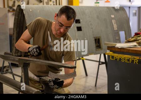 Tech.Sgt.Zachary Johnson, 19th escadron de maintenance artisan de la construction d'aéronefs, marteaux un morceau de tôle à la base aérienne de Little Rock, Arkansas, le 31 août 2021.Un marteau est l'un des nombreux outils qu'un spécialiste de la tôlerie peut utiliser pour plier, façonner ou former du métal ou des tubes afin de répondre aux besoins de la mission. Banque D'Images
