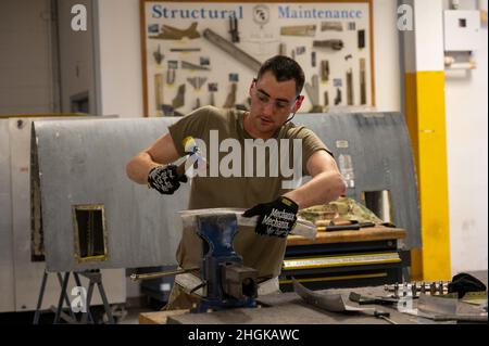 Tech.Sgt.Zachary Johnson, 19th escadron de maintenance artisan de la construction d'aéronefs, marteaux et cintrages un morceau de tôle à la base aérienne de Little Rock, Arkansas, le 31 août 2021.Les spécialistes de la tôlerie utilisent différents outils pour répondre à leurs besoins, allant des outils à main simples aux machines industrielles de plus grande taille. Banque D'Images